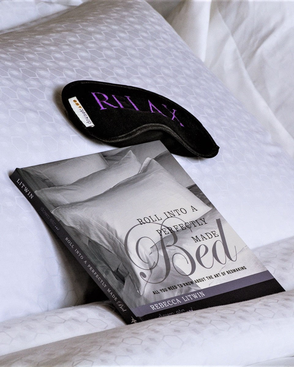 book and eyemask on pillow