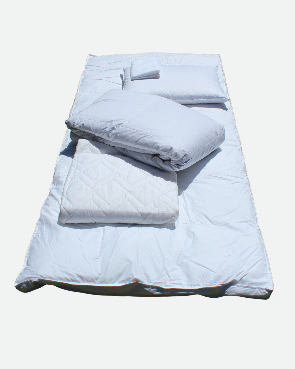 college dorm bedding kit parts laid on ground