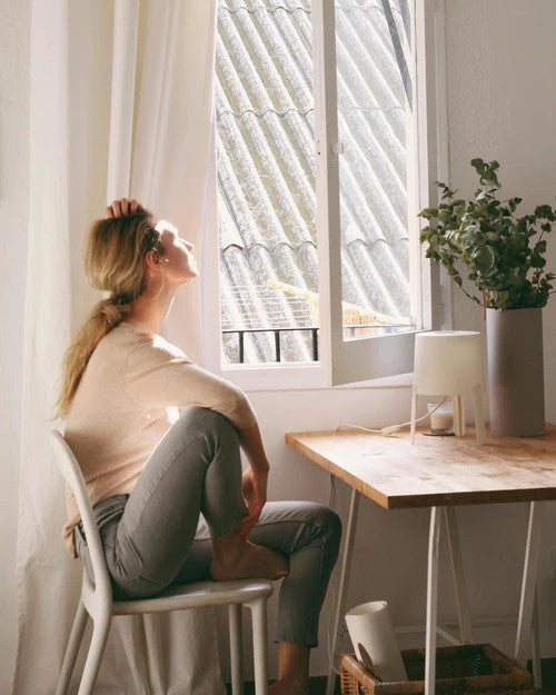 woman sitting in front of open window