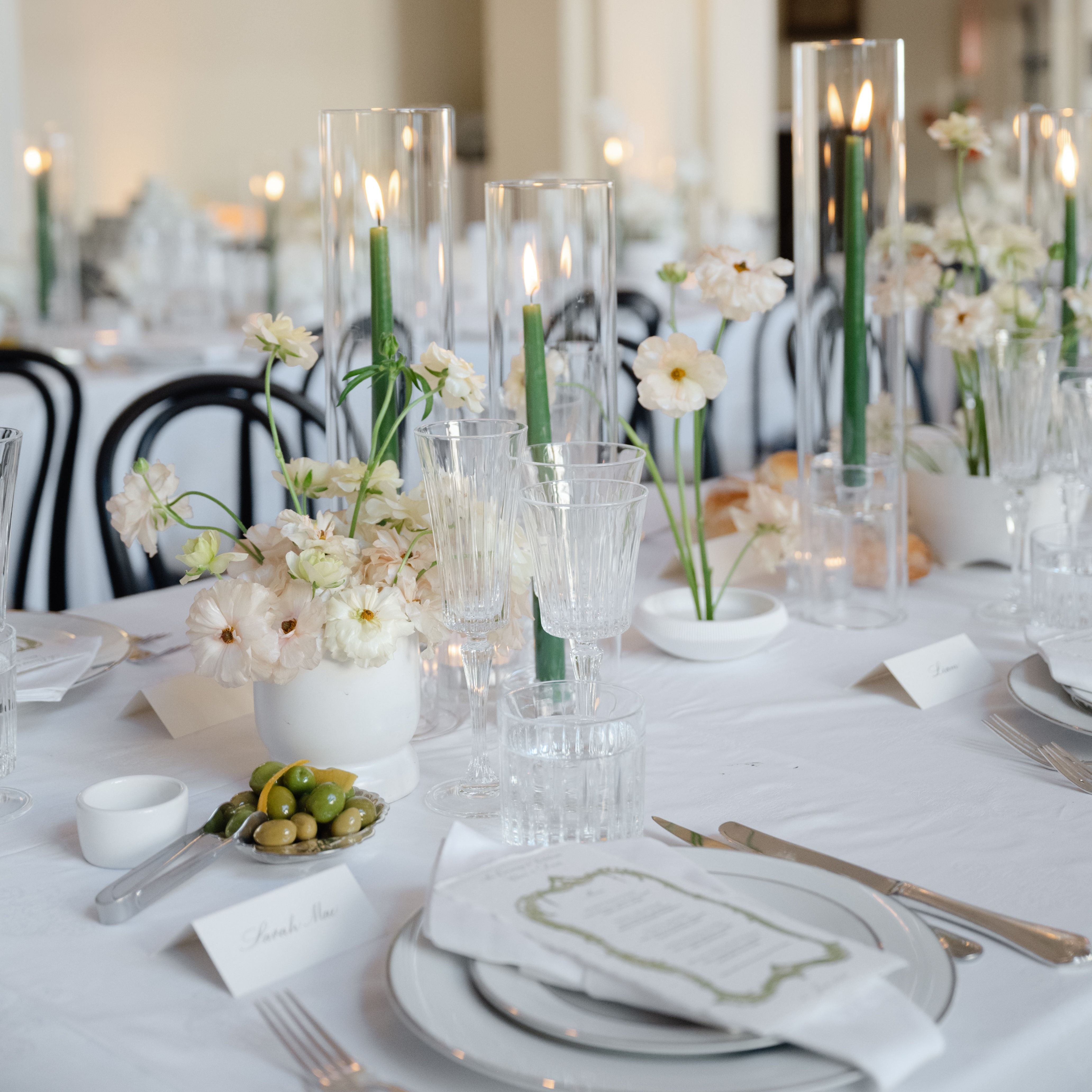 Elegant table setting with floral arrangements and candles in a formal dining room.