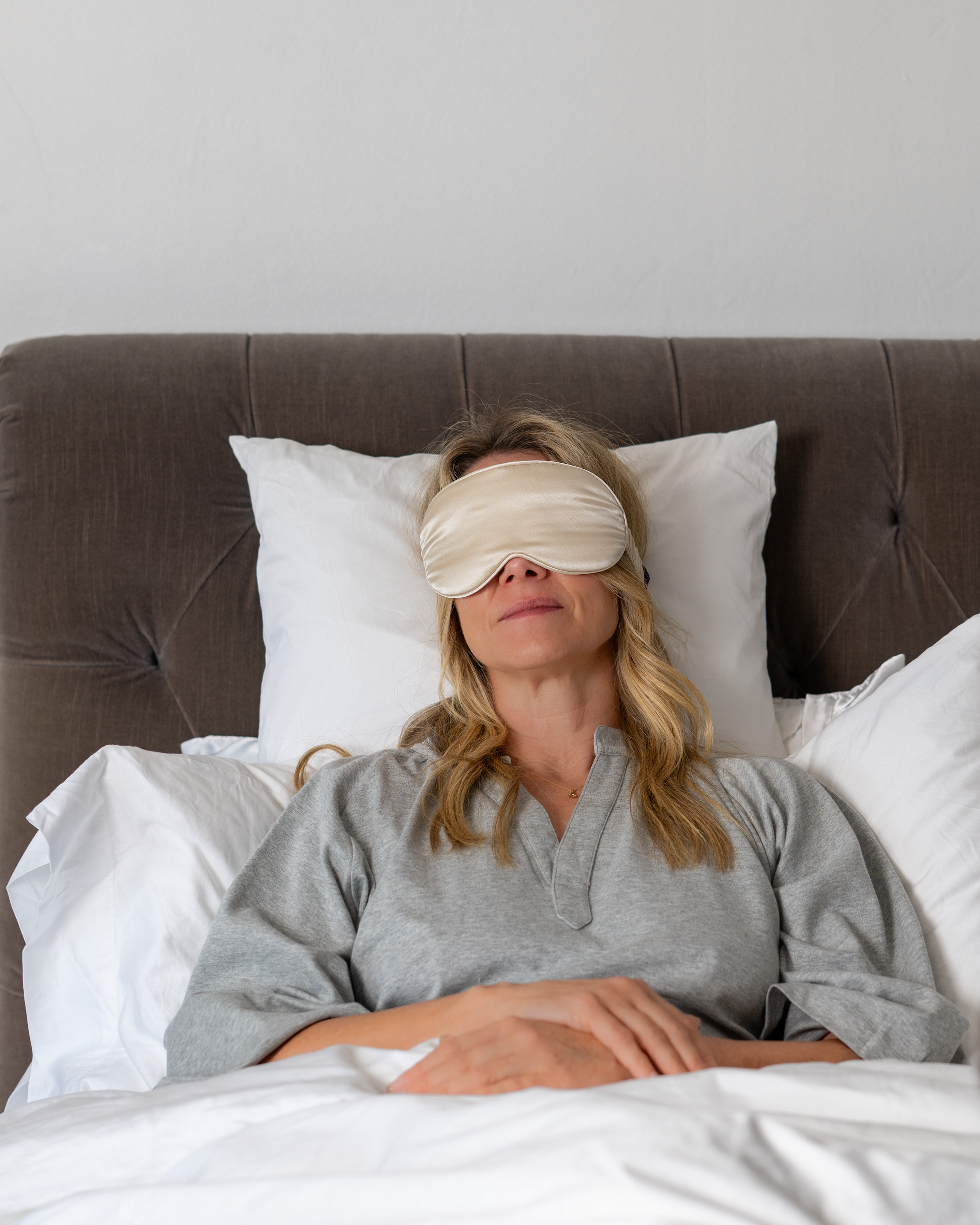 woman in bed wearing eye mask