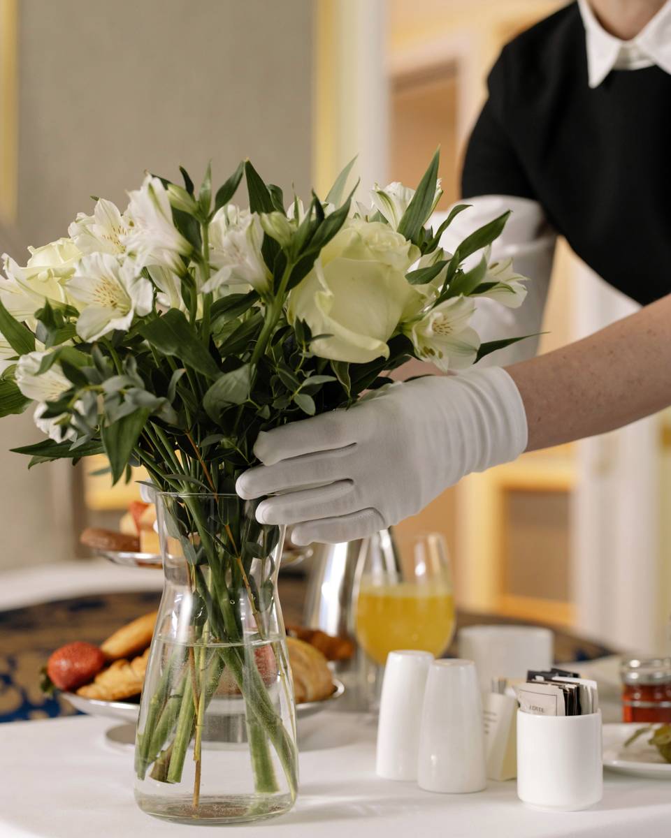 housekeeper straightening vase of flowers