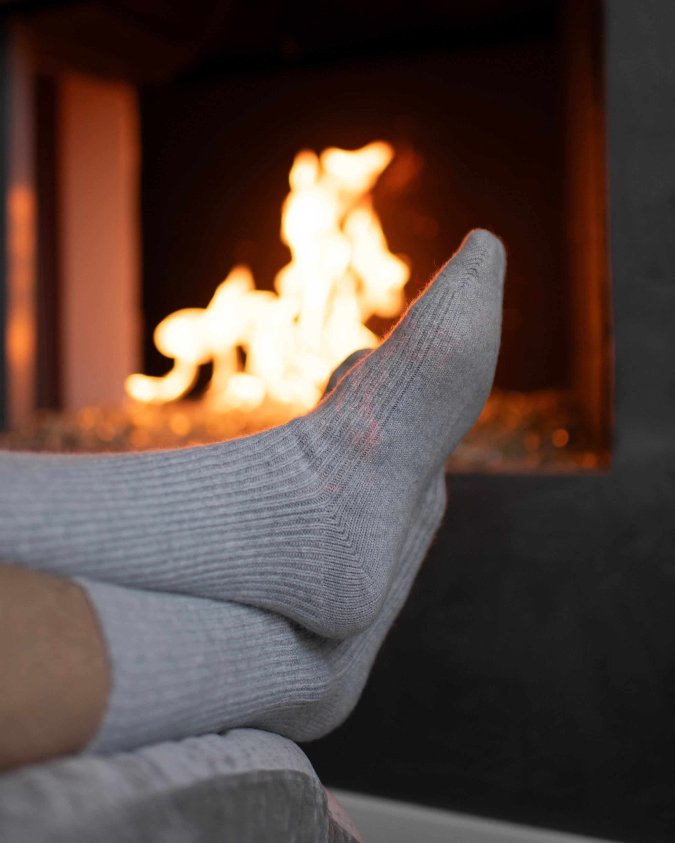 socked feet in front of fireplace