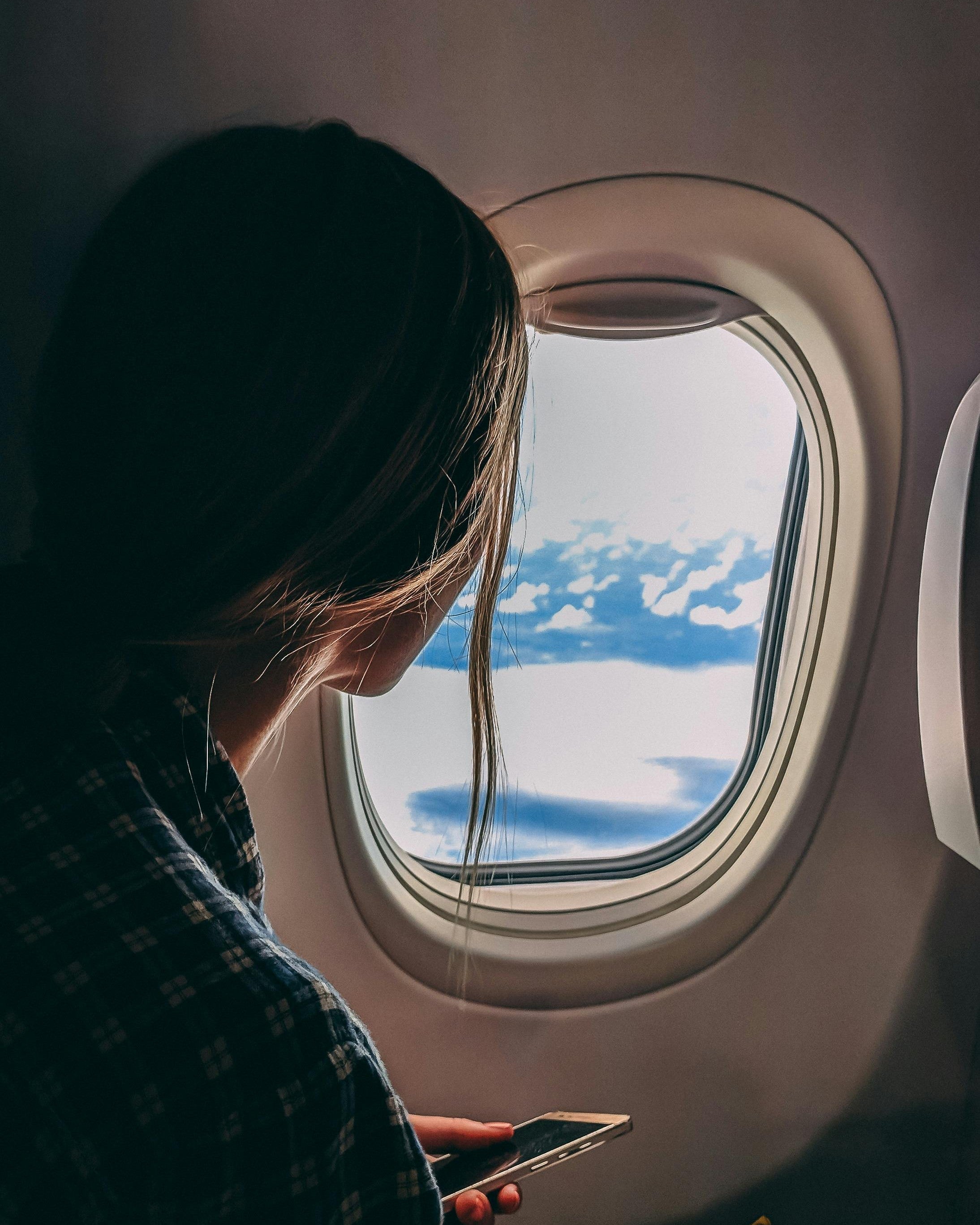 woman looking out of airplane window