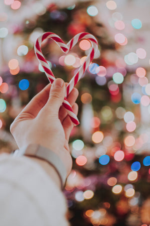 hand holding candy canes in heart shape