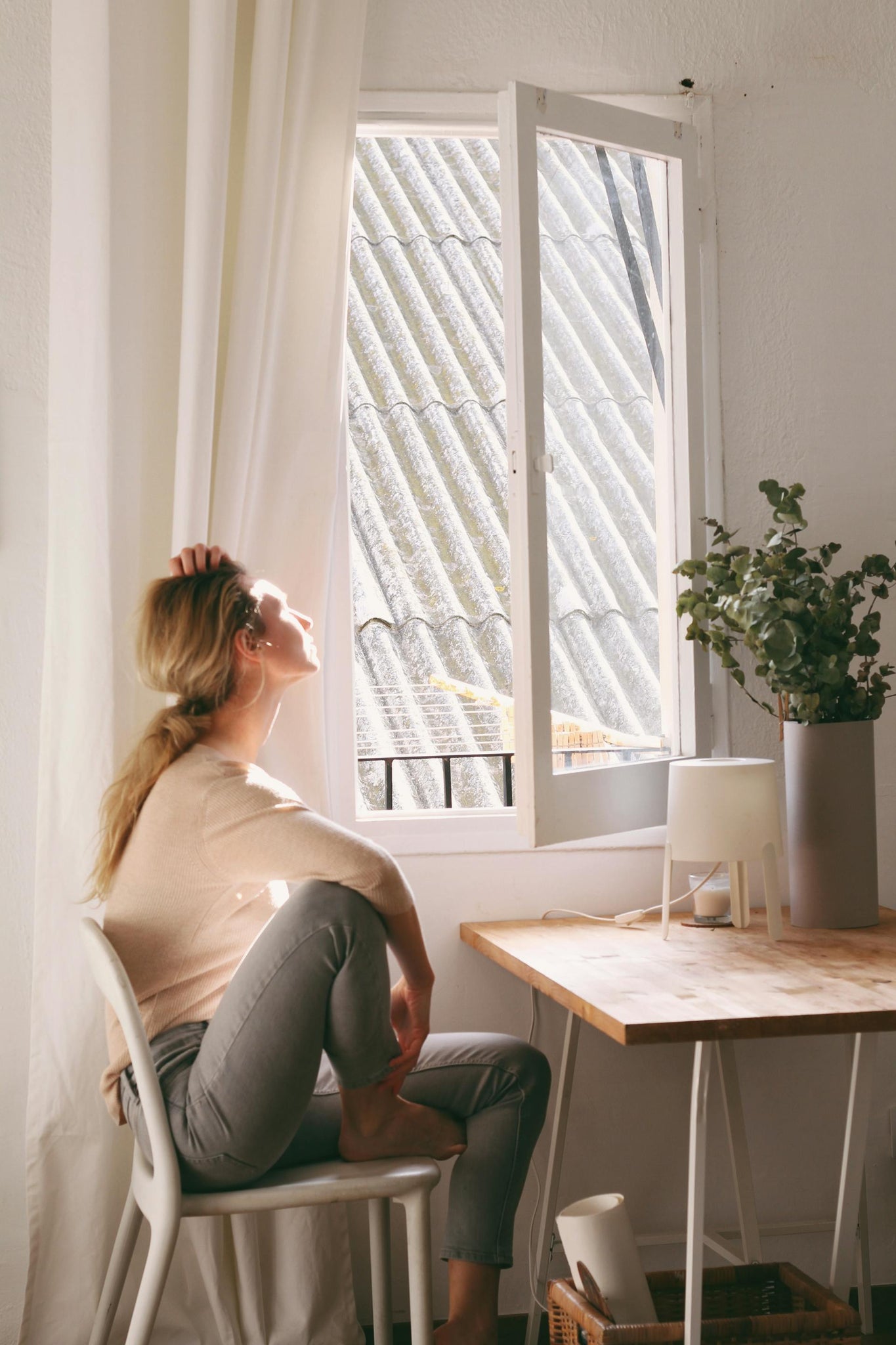 woman sitting in front of open window